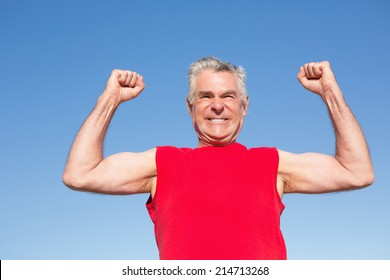 Active senior man cheering in red tank top on a sunny day - Powered by Shutterstock