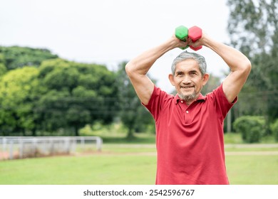 active senior man doing exercise with dumbbell outdoors in the nature park,elderly lifestyle,workout activity,health benefit in nature