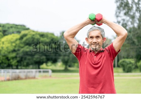 active senior man doing exercise with dumbbell outdoors in the nature park,elderly lifestyle,workout activity,health benefit in nature