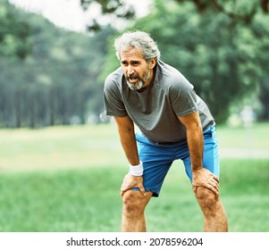 Active Senior Man Exhausted Tired Resting After Running Jogging Exercising  In The Park