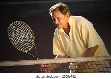 Active Senior Man In His 70s Is Playing Tennis.