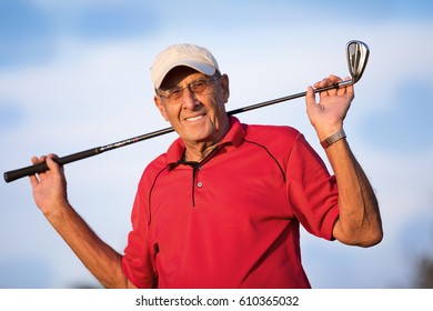 Active senior man portrait holding a nine iron golf club
