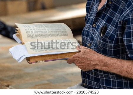 Active Senior man Reading an Open Book Contemplatively on a Wooden Park Bench in a Lush Green Park, Lifestyle, Contemplation, Education, Retirement, Active Aging