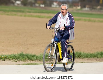 Active senior man riding a bicycle on countryside