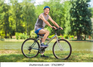 Active senior man riding a bike in park on a beautiful summer day shot with tilt and shift lens