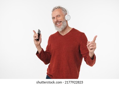 Active senior mature middle-aged man listening to the music song playlist e-book podcast in headphones on cellphone in mobile application online isolated in white background - Powered by Shutterstock