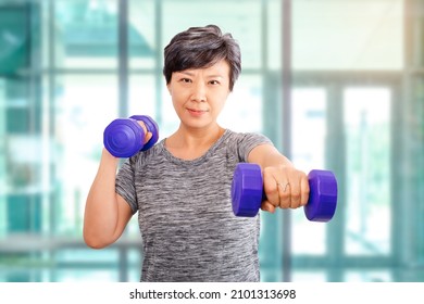 Active Senior Older Asian Attractive Elder Woman Training, Exercising, Workout At The Gym In A Health Club With Lifting Weights Dumbbells. Older Senior Adults Exercise At Fitness Gym Club Ideas.