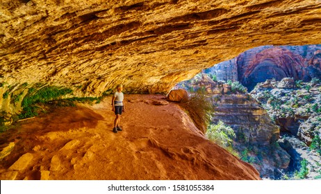 Active Senior Woman In A Cave On A Hike On The Canyon Overlook Trail In Zion National Park, Utah, United States