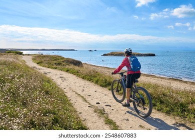 active senior woman cycling with her electric mountain bike at the wild coast of Quiberon peninsula, Brittany, France
 - Powered by Shutterstock