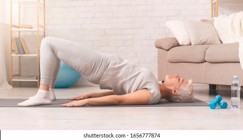 Active Senior Woman Doing Back Exercise On Floor At Home, Panorama