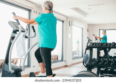 Active senior woman excercising on stepper at gym to stay fit. Cardio excercises for mature people. Athleticspirit concept