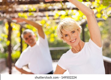 Active Senior Woman Exercising With Husband Outdoors