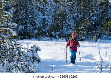 active senior woman hiking with snow shoes in deep powder snow in the  Hochhaedrich area of Bregenz Forest in Vorarlberg, Austria - Powered by Shutterstock