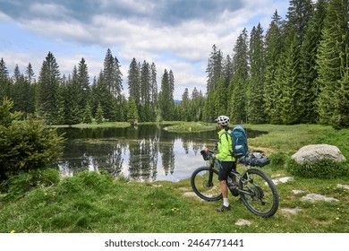 active senior woman on a bike packing tour with her electric mountain bike in the Bavarian Forest National Park, Bavaria, Germany - Powered by Shutterstock