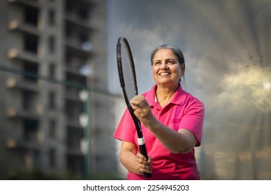 Active senior woman playing tennis on court. - Powered by Shutterstock