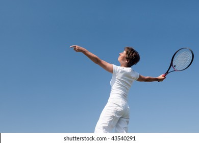 Active Senior Woman Is Playing Tennis In Front Of Blue Sky