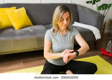 Active senior woman setting up her fitness app on her smartwatch before exercising at home  - Powered by Shutterstock