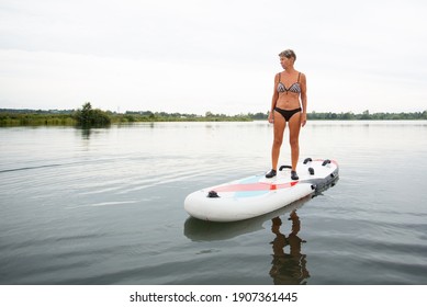 Active Senior Woman In Swim Suit Standig On Paddle Board In The Water 