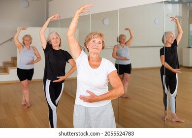 Active Senior Woman Visiting Choreography Class With Group Of Aged Females, Practicing Classical Ballet Technique.