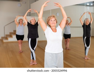 Active Senior Woman Visiting Choreography Class With Group Of Aged Females, Practicing Classical Ballet Technique.