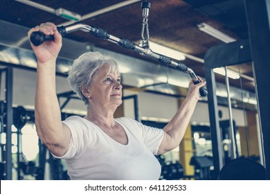 Active Senior Woman Working Exercise In The Gym. 