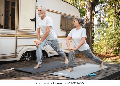 Active seniors lifestyle. Caucasian senior old elderly couple spouses husband and wife grandparents doing physical activity, fitness working out stretching on sporty mats on a holiday by trailer - Powered by Shutterstock