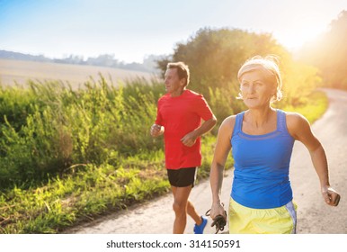 Active Seniors Running Outside In Green Nature