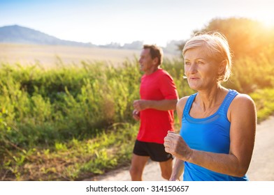 Active Seniors Running Outside In Green Nature