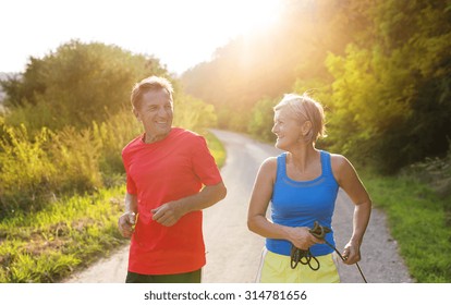 Active Seniors Running Outside In Green Nature