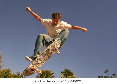 Active skateboarder jumping and performing a trick in a ramp of a skate park - Powered by Shutterstock