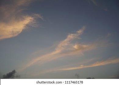 Active sky image with moving shapes and wispy line of thin colorful warm pink and orange clouds.  The stormy spring transition to summer brings a variety of cloudscape views to po
