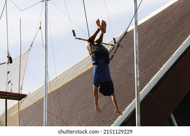 Active sports and leisure on the trapeze. Against the background of the blue sky, in addition to sportsmen(s), trapeze structures in a shot.