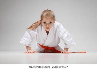 Active sports training for children, a small child is doing push-ups in a kimono. - Powered by Shutterstock