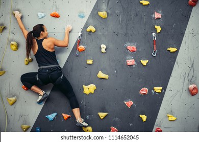 Active Sporty Woman Practicing Rock Climbing On Artificial Rock In Climbing S. Extreme Sports And Bouldering Concept.
