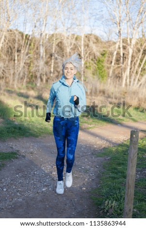 Active and sporty woman runner in autumn nature