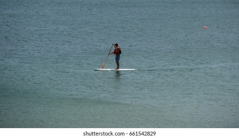 Active surfer on paddle board surfing in ocean.
