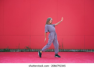 Active Teen Girl Dancing Outdoors On Red Wall Background. Stylish Modern Young Dancer Perform Contemporary Hip Hop Dance