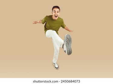 Active teen, smart young man cute teenage person lifting leg, dancing. Showing amusing, entertaining or enjoyable move for pleasure, playful boy in funny and not serious jump, physically energetic kid - Powered by Shutterstock