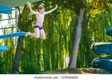 Active Teenager Boy Jumping Into An Outdoor Pool From Spring Board Or 5 Meters Diving Tower Learning To Dive During Sport Class On A Hot Summer Day. Happy Brave Child.