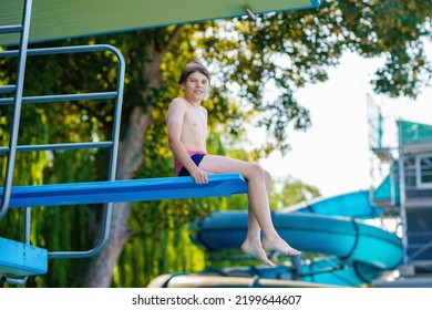 Active Teenager Boy Jumping Into An Outdoor Pool From Spring Board Or 5 Meters Diving Tower Learning To Dive During Sport Class On A Hot Summer Day. Happy Brave Child.