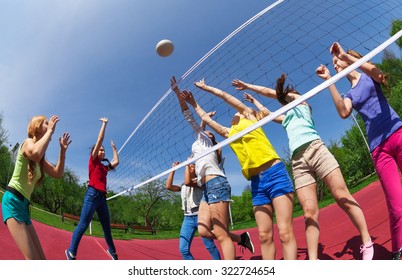 Active Teenagers Playing Volleyball On The Game Court Together Outside During Summer Sunny Day