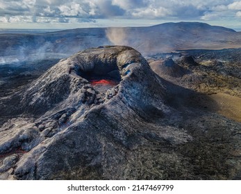 active volcano on the Reykjanes Peninsula of Iceland. Volcanic crater with liquid magma. Liquid lava in the center of the crater just before eruption. Hills and mountains of countryside in daytime sun