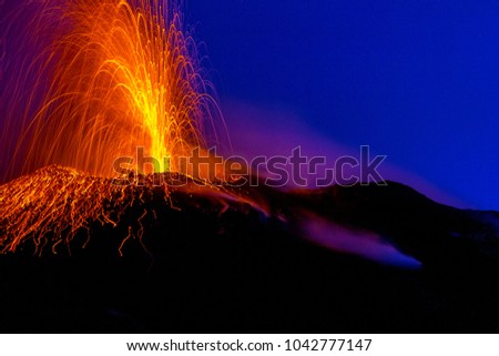 active volcano spraying lava into the night on Stromboli island in Italy