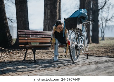 Active woman adjusting bicycle chain on a sunny day in the park. - Powered by Shutterstock