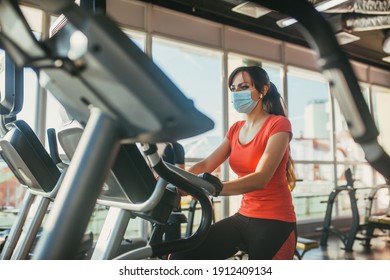 An active woman in a protective medical mask training in gym, during COVID-19 epidemic. Sport and quarantine. - Powered by Shutterstock