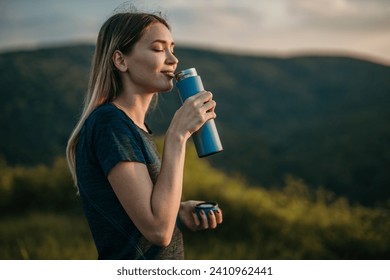 Active woman sips water, staying hydrated after jogging outdoor - Powered by Shutterstock