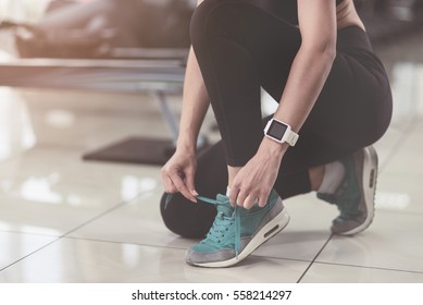 Active woman tying her shoelaces after training - Powered by Shutterstock