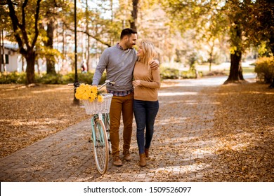 Active young couple enjoying together in riding bicycle at golden autumn park - Powered by Shutterstock