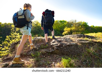 Active Young Couple Hiking In The Forest During Summer. Travel, Hiking, Backpacking, Tourism And People Concept