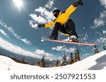 Active young snowboarder jumps from the kicker at ski resort. Winter sports active weekend concept